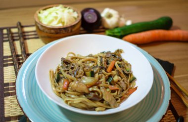 Sebzeli pirinç eriştesi ve beyaz kasede et. Ahşap arka. Kapatın. Üst görünüm