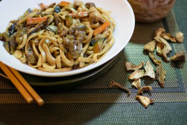 Sebzeli pirinç eriştesi ve beyaz kasede et. Koyu yeşil arka plan. Kapatın. Üst görünüm