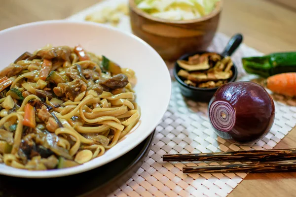 Sebzeli pirinç eriştesi ve beyaz kasede et. Beyaz arka plan. Kapatın. Üst görünüm