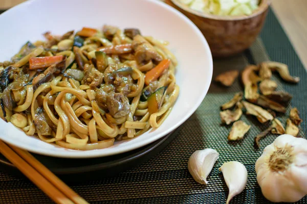 Sebzeli pirinç eriştesi ve beyaz kasede et. Koyu yeşil arka plan. Kapatın. Üst görünüm