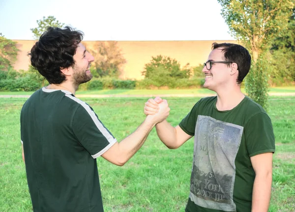 Két Barát Pacsizik Boldogan Edzés Után Parkban Fűvel Napsütéses Napon — Stock Fotó