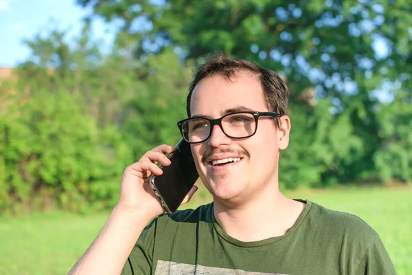 Fiatal Férfi Szemüveges Generációs Vagy Kocka Koncepció Beszél Mobilján Parkban — Stock Fotó