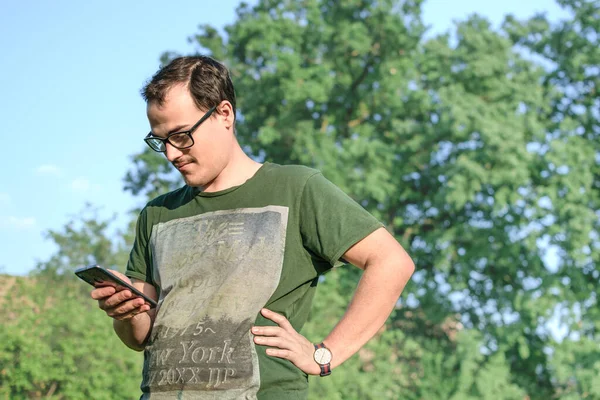 Fiatal Férfi Szemüvegben Mint Generációs Vagy Kocka Koncepció Mobiljára Parkban — Stock Fotó
