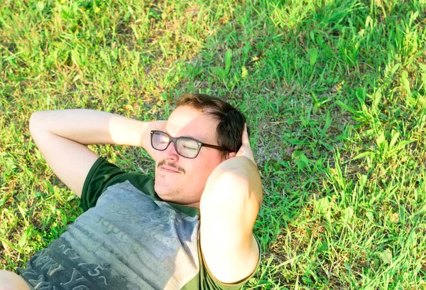 Fiatal Férfi Szemüveggel Zöld Pólóval Felüléseket Csinál Parkban Edz Fűvel — Stock Fotó