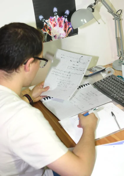 眼鏡をかけた青年がパソコンを持って机で勉強している 学術的概念 試験および研究における千年の世代 — ストック写真