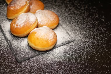 Siyah zarif arkaplanda serpiştirilmiş serpiştirilmiş Alman Geleneksel Krapfen resmi