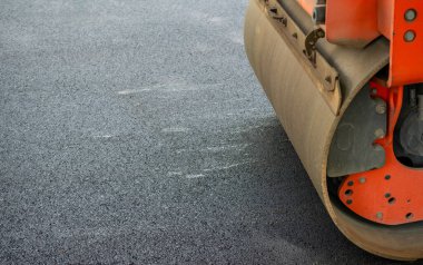 Yolda asfalt kaldırım için silindirli Turuncu Traktör resmi