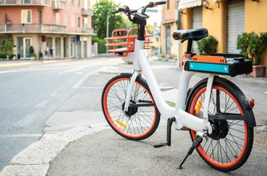 Cep telefonu uygulaması tarafından ekolojik kullanım için sokakta park edilmiş elektrik bisikleti resmi