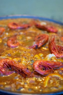 Paella 'nın tanıdık bir ortamda pişirme işlemi görüntüsü. İspanyol tarifi pirinç, deniz ürünleri ve tavşandan yapılır.