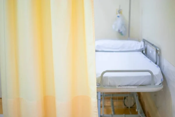 Image of Hospital bed or stretcher with light yellow curtain as Copy space