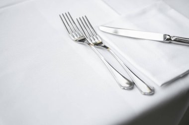 Zarif Restoran masasındaki çatal bıçak, masa örtüsü ve peçetenin yakın görüntüsü