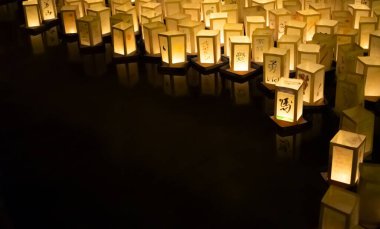Japonya 'nın, Hiroşima ve Nagasaki' nin atom bombalarının anısına geceleyin suda yüzen kağıt fenerlerle seremoni resmi.
