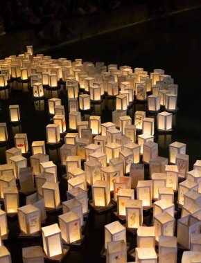 Japonya 'nın, Hiroşima ve Nagasaki' nin atom bombalarının anısına geceleyin suda yüzen kağıt fenerlerle seremoni resmi.