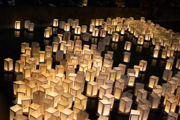 Japonya 'nın, Hiroşima ve Nagasaki' nin atom bombalarının anısına geceleyin suda yüzen kağıt fenerlerle seremoni resmi.