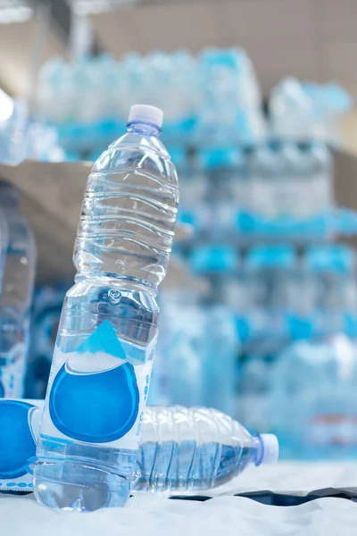 Image of Water bottles stored on supermarket shelves for sale and consumption