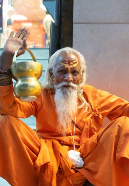 Hindistandaki sofu keşiş Sadhu, sakallı, beyaz saçlı ve yüzü boyalı kameraya bakarak vaaz veriyor.