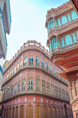 Bikaner 'deki Dulmera Havelis' in yeşil tonlu ve turistik kırmızı cepheli görüntüsü, Hindistan.