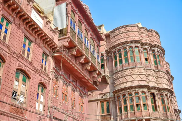 Stock image View of Dulmera Havelis in Bikaner with windows in green tones and touristy red facades, India.