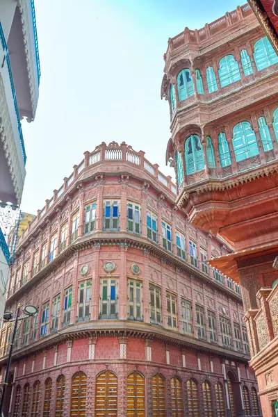 Stock image View of Dulmera Havelis in Bikaner with windows in green tones and touristy red facades, India.