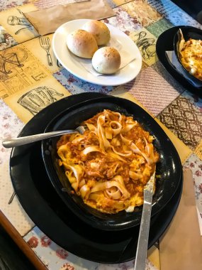 close-up of the plate with delicious bolognese pasta and garlic bread