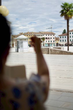 Piazza Grande Palmanova ön plandaki sokak sanatçısının kolu ve fırçasıyla bulanıklaştı