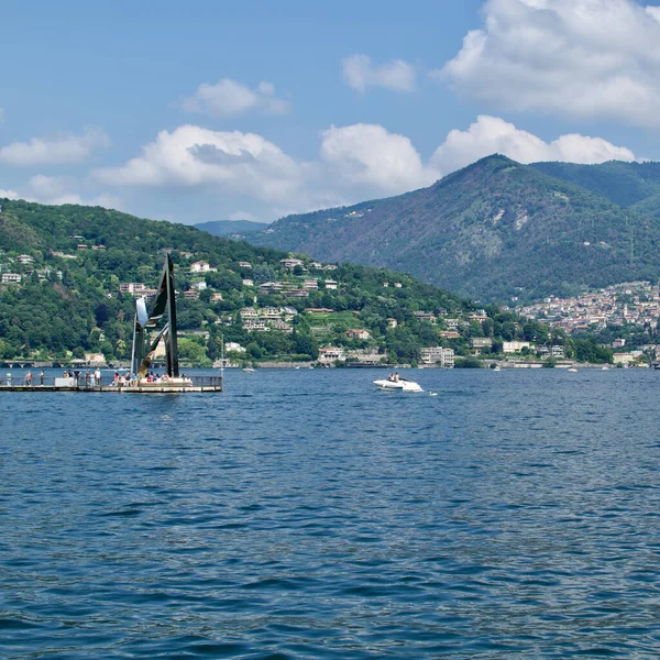 Como, İtalya - 20 Haziran 2023: Güneşli yaz günlerinde Como Gölü 'nde yürüyen turistler. Gölde bir sürü özel tekne var..