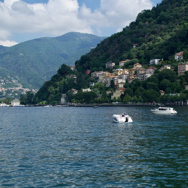 Como, İtalya - 20 Haziran 2023: Güneşli yaz günlerinde Como Gölü 'nde yürüyen turistler. Gölde bir sürü özel tekne var..