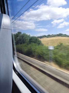 Hızlı tren pencerelerinden italyan kırsalının manzarası dinleniyor
