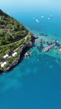 İtalya 'nın güneyindeki Dino adasının doğal güzelliğini gösteren dairesel yörünge dikey hava aracı yaz güneşinde kristal ve turkuaz tonlarıyla çevrili.