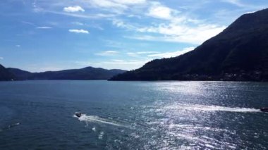 Hızlı motorlu teknelerin ve yavaş eski teknelerin, yaz sabahı Como Gölü 'nde kendilerini geçişlerinin nefes kesici görüntüsü.