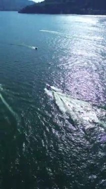 Hızlı motorlu teknelerin ve yavaş eski teknelerin, yaz sabahı Como Gölü 'nde kendilerini geçişlerinin nefes kesici görüntüsü.
