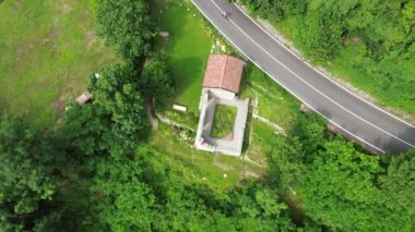 Como yakınlarındaki Ponzate kasabasındaki Kutsal Bakire Şapeli 'ni gösteren sinematik hava manzarası. Etrafı dağlarla ve açgözlü ağaçlarla kaplı vadiyle çevrili.