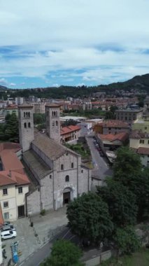Saint Abundius Bazilikası 'nın dikey sinematik görüntüsü ve Como Gölü' nün arka planında yaz güneşi ışığı.