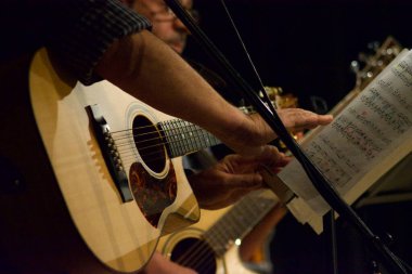 Tiyatro konserinde gitar çalan müzisyenlerin ellerini kapatın.
