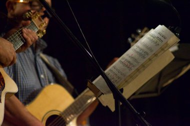 Tiyatro konserinde gitar çalan müzisyenlerin ellerini kapatın.