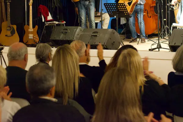 Seyirciler, tiyatro konserinin sonunda müzisyenleri alkışlıyor.