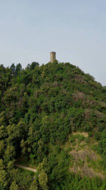 Como şehrinin tarihi Baradello kulesinin tepesindeki yeşil dağın havadan kuş manzarası.