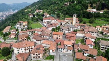 Tipik bir İtalyan kasabasının havadan görünüşü Como Gölü 'nün yanındaki dağda ilk uçakla çan kulesiyle birlikte.