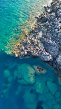 Hipnotize edici mavi bir denizde koşan beyaz küçük bir tekne hakkında tepeden sinematik hava manzarası