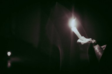 Cadılar bayramında karanlık bir odada dezenfektanla bir sprey şişesini tutarken.