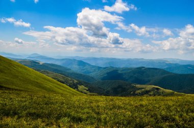 Dağları ve mavi gökyüzü olan güzel bir manzara.