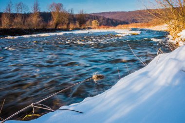 Akşamları ormanda buzlu kış nehri