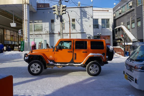 日本北海道 2022年12月19日 一辆时尚的橙色吉普车在北海道雪地覆盖的路上行驶 — 图库照片