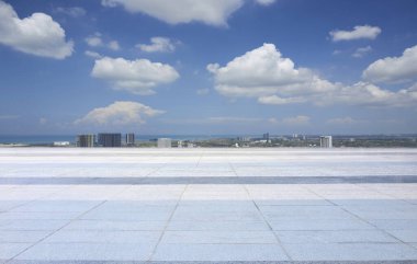 Geniş açık alan, boş zemin ve mavi gökyüzü ve beyaz bulutlu şehir.