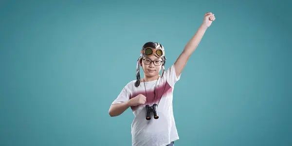 Playful Asian Child Pilot Attire Imagines Soaring High Teal Background Stock Picture
