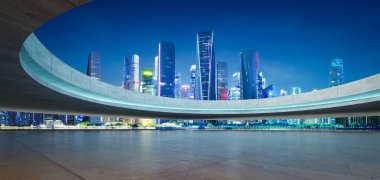 Karanlık çöktüğünde kıvrımlı bir yapı tarafından çerçevelenmiş canlı bir şehrin eşsiz perspektifi. 3B görüntüleme