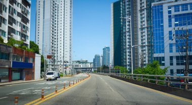 Uzun binalar ve hareketli bulanık yol ile güneşli şehir sokak manzarası