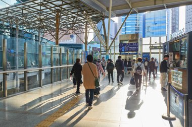 Seul, Güney Kore - 18 Mayıs 2024: Güney Kore 'de güneşli bir tren istasyonundan geçerek şehir yaşamını ve ulaşımı ön plana çıkaranlar