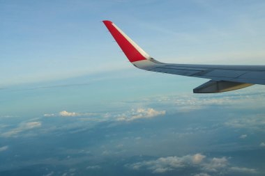 Uçak kanadı güzel mavi bir gökyüzünde uçuyor kabarık bulutlarla