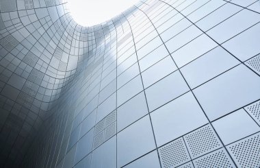 Çağdaş bir binanın dış duvarı metal panellerle kaplıdır ve fütüristik ve soyut bir mimari tasarım yaratır.